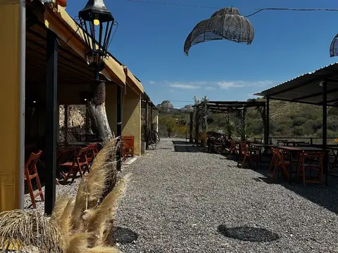 La galería del parador con mesas al aire libre y las sierras al fondo
