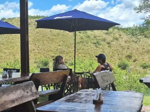 Mesas con sombrillas en la terraza, mirando las sierras