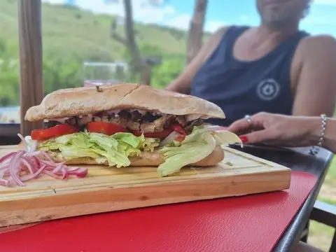Sándwich de carne a la parrilla servido en tabla de madera