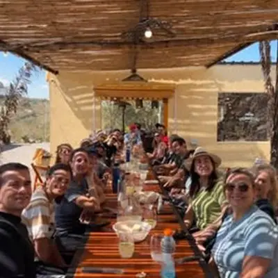 Una mesa larga de amigos almorzando en el parador